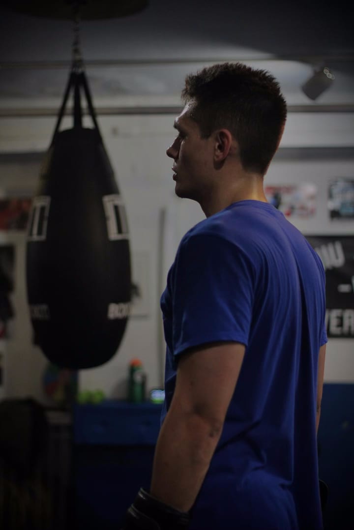 Un boxeador frente al saco pesado durante una clase de la tarde