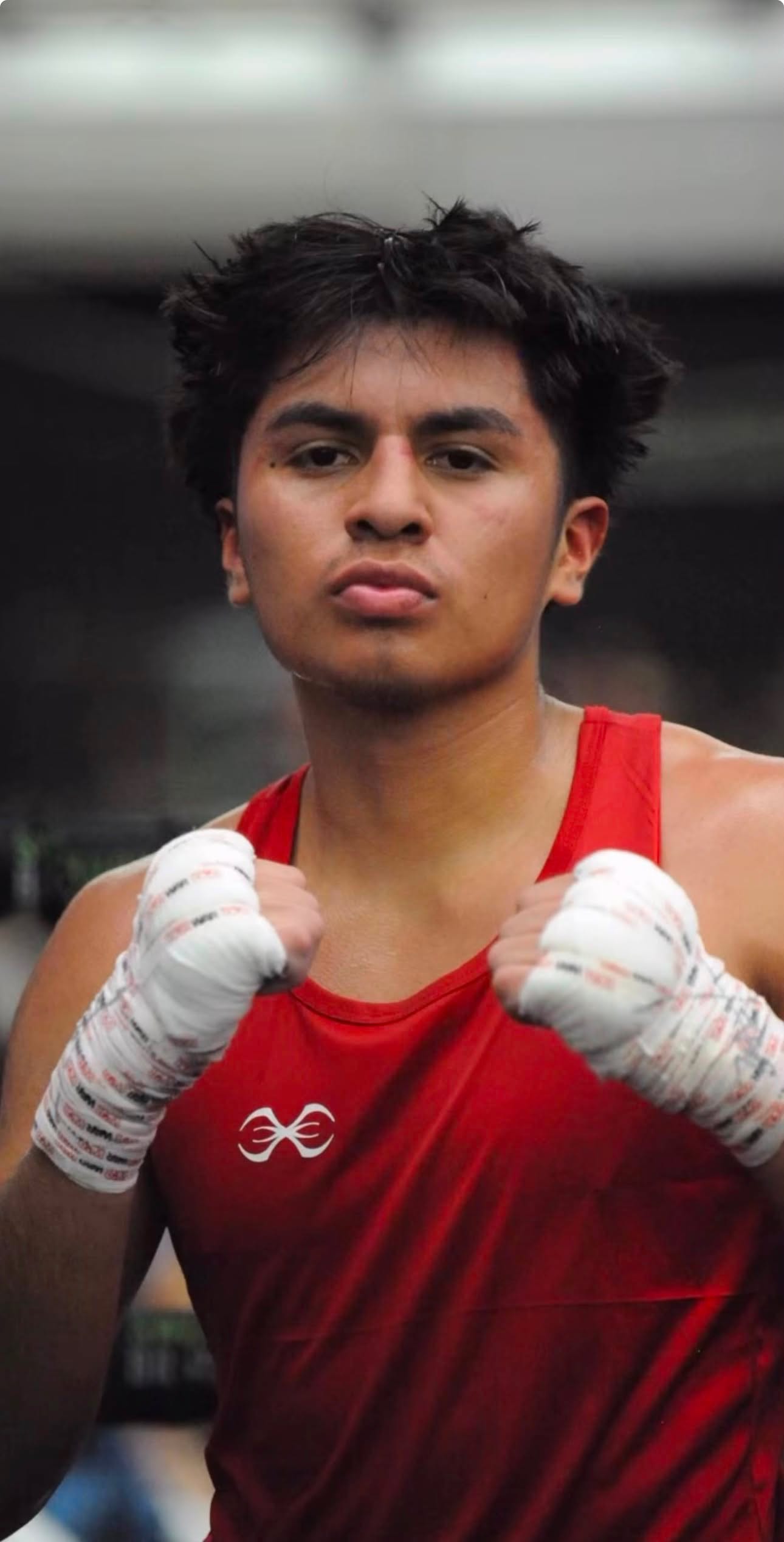 Un boxeador amateur de Ironhand con camiseta roja de competencia y las manos vendadas
