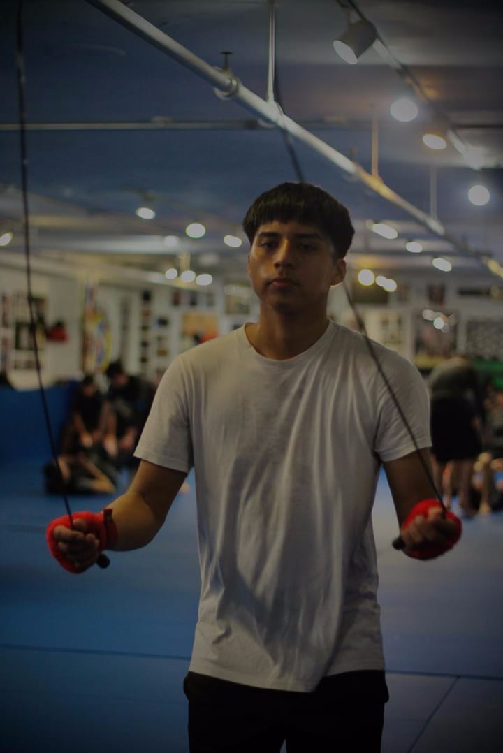 Un miembro de Ironhand con los guantes puestos, listo para entrenar en el piso del gimnasio