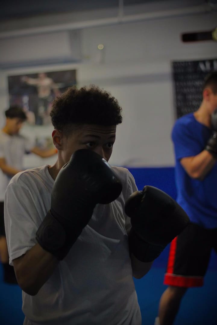 Un boxeador adolescente manteniendo la guardia durante una clase en Ironhand Boxing